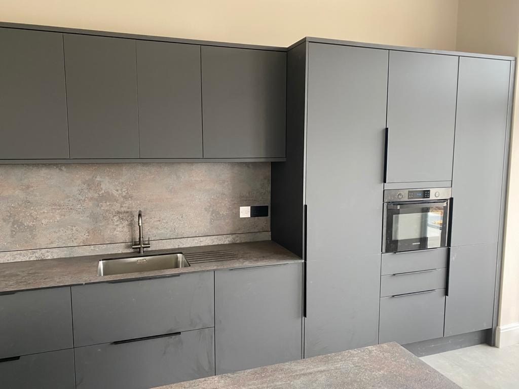 Handleless grey fitted kitchen with integrated appliances