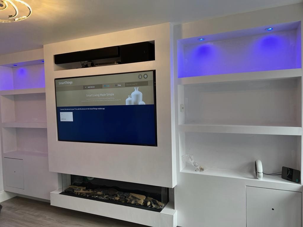 Media wall with lit display niches and an inset electric fire